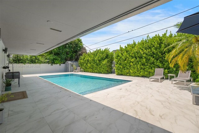 15100 SW 89th Ct, Palmetto Bay, FL 33176 - view of swimming pool featuring a fenced in pool, a patio, an outbuilding, and a shed