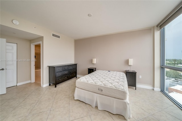 bedroom with access to outside, light tile patterned floors, and a wall of windows