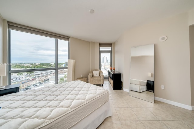 bedroom featuring light tile patterned floors and a wall of windows