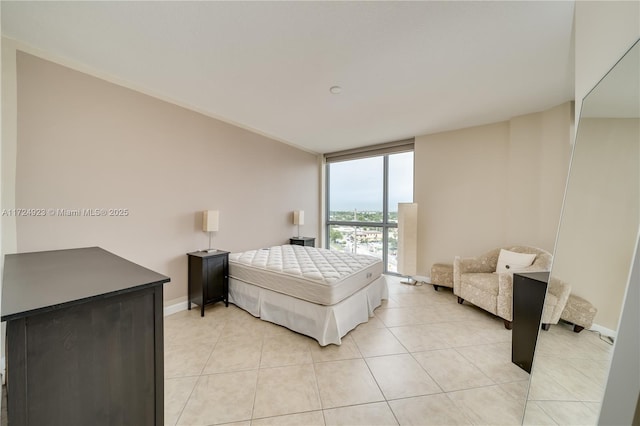 bedroom with expansive windows and light tile patterned flooring