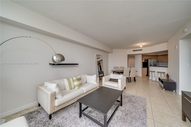 living room with light tile patterned floors and a textured ceiling