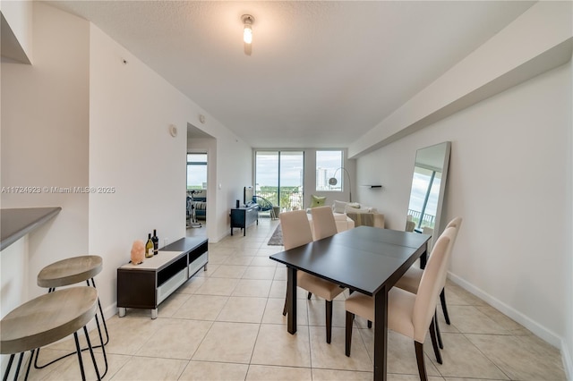 tiled dining area featuring expansive windows