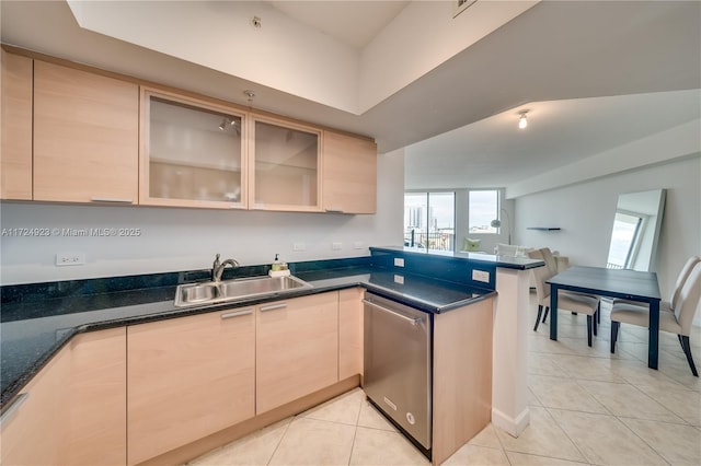 kitchen with dishwasher, light brown cabinetry, light tile patterned floors, and sink