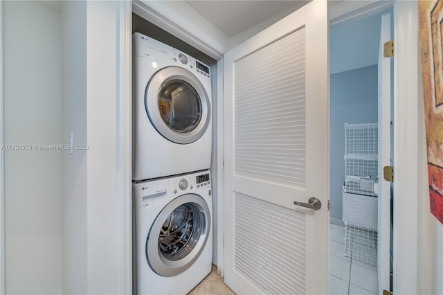 laundry area featuring light tile patterned floors and stacked washer / drying machine