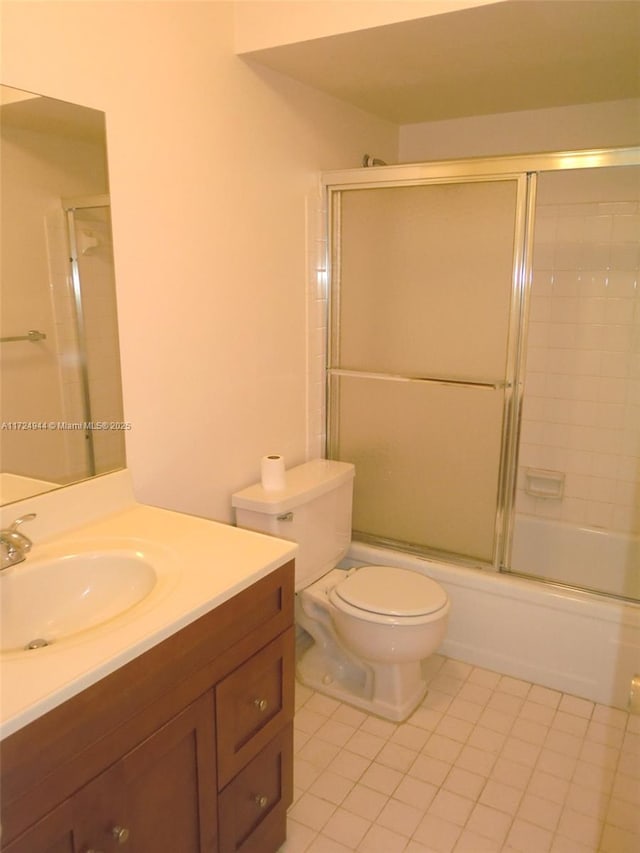 full bathroom featuring tile patterned flooring, combined bath / shower with glass door, toilet, and vanity