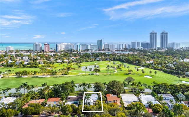 aerial view with golf course view, a view of city, and a water view