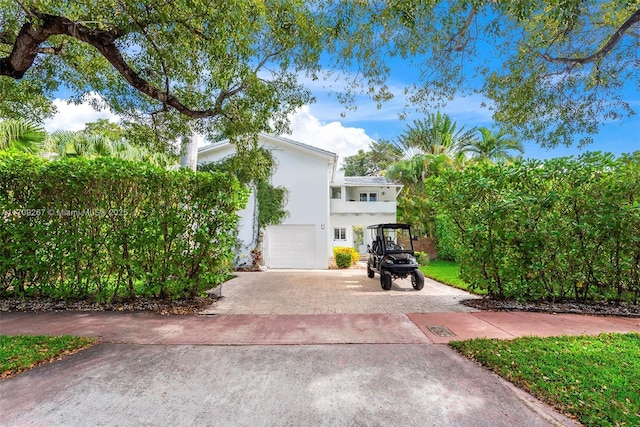 view of side of property featuring stucco siding, driveway, and a garage