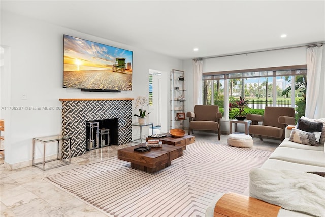 living room with a tiled fireplace, recessed lighting, marble finish floor, and baseboards