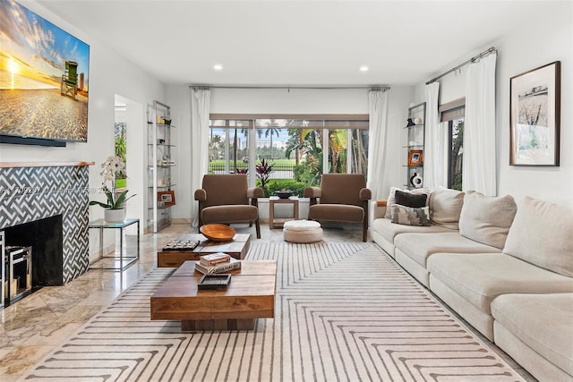 living area featuring recessed lighting, marble finish floor, and a tiled fireplace