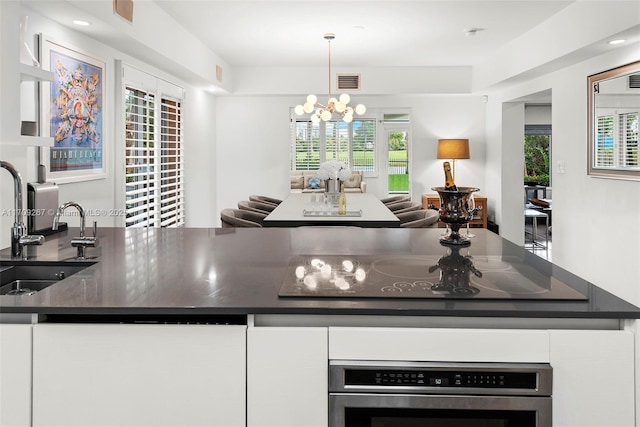 kitchen with oven, visible vents, dark countertops, and a sink