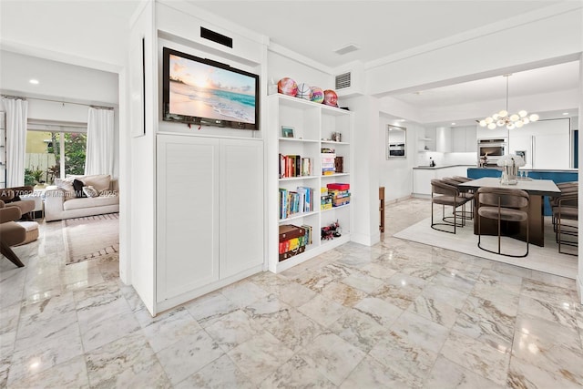 interior space with a notable chandelier, marble finish floor, open floor plan, white cabinets, and stainless steel oven