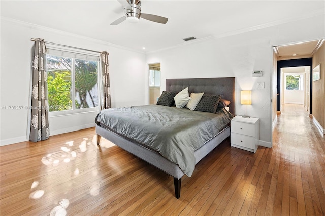 bedroom featuring visible vents, wood-type flooring, and ornamental molding