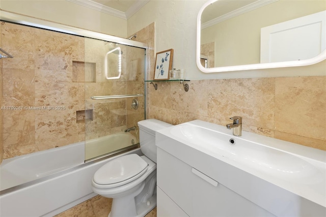 bathroom with tile walls, toilet, bath / shower combo with glass door, and ornamental molding