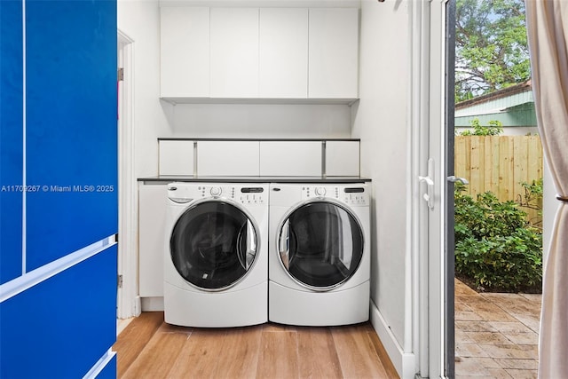 laundry room featuring washing machine and dryer and light wood-style flooring