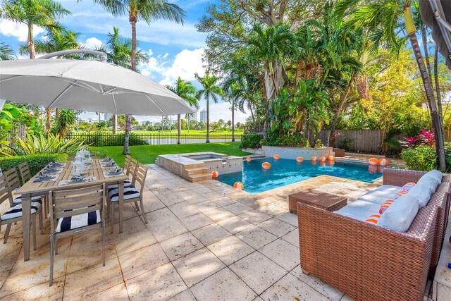 view of swimming pool featuring a yard, a fenced backyard, a patio area, outdoor dining space, and an in ground hot tub