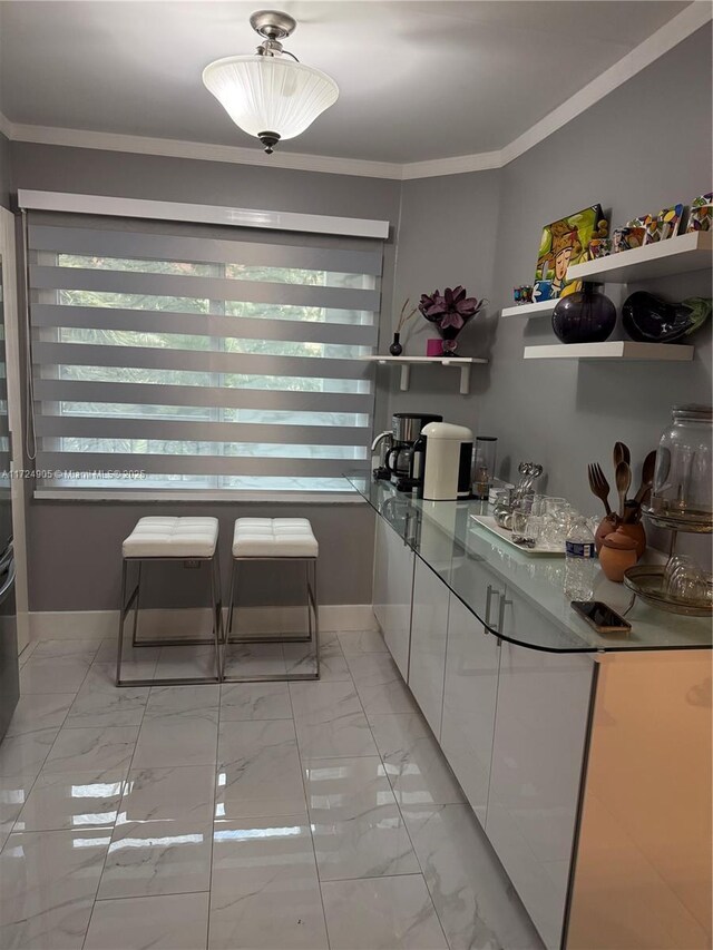 kitchen featuring plenty of natural light, white cabinetry, and crown molding