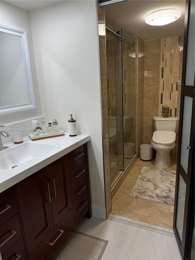 bathroom with toilet, vanity, and walk in shower