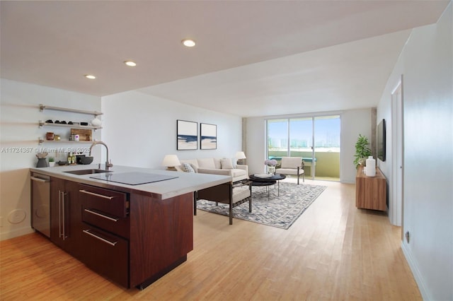 kitchen with dishwasher, sink, light wood-type flooring, black electric cooktop, and dark brown cabinetry