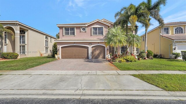 view of front of house with stucco siding, a front lawn, driveway, a tile roof, and an attached garage