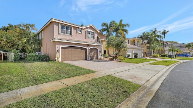 mediterranean / spanish-style house featuring a tile roof, a front yard, stucco siding, driveway, and an attached garage