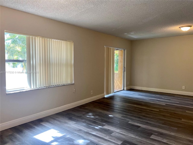 unfurnished room featuring dark hardwood / wood-style flooring and a textured ceiling