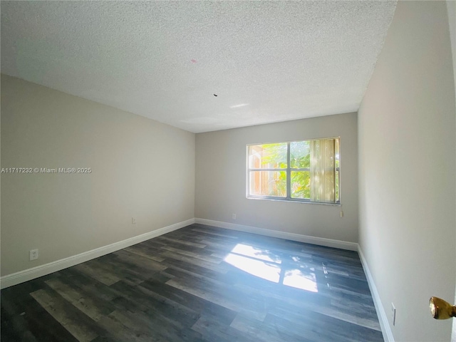 unfurnished room featuring dark hardwood / wood-style floors and a textured ceiling