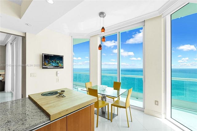 dining space featuring light tile patterned floors, a wealth of natural light, a wall of windows, and crown molding