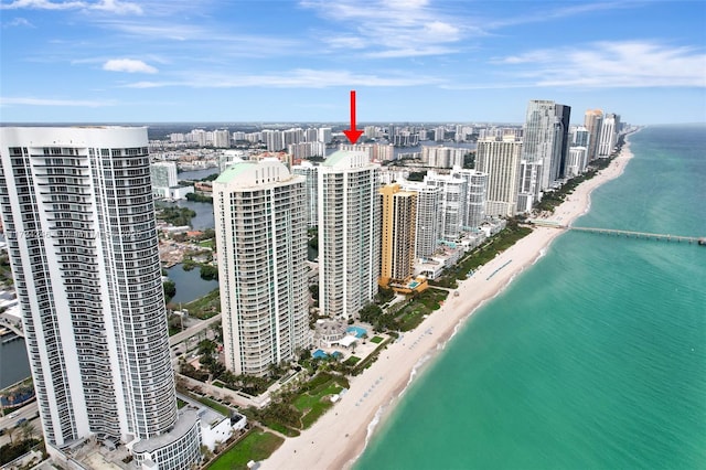 birds eye view of property featuring a water view and a beach view