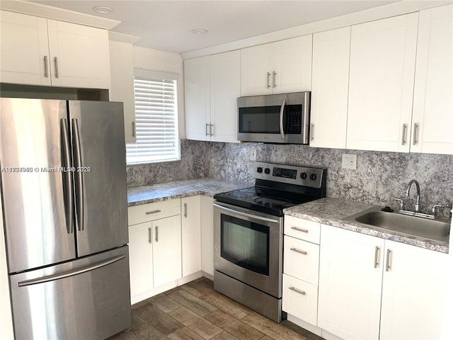 kitchen with tasteful backsplash, white cabinetry, sink, and appliances with stainless steel finishes