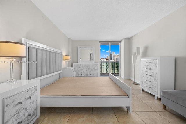 tiled bedroom with a textured ceiling and access to outside