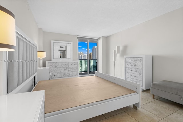 bedroom featuring a textured ceiling, access to outside, and tile patterned floors