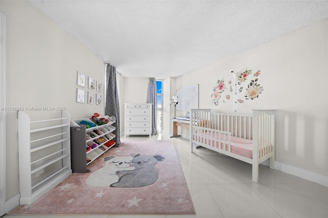 bedroom with a crib, a textured ceiling, and tile patterned floors