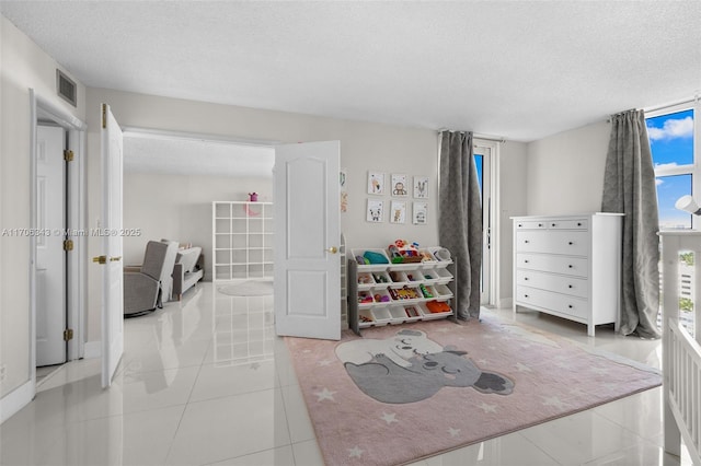 tiled bedroom featuring a textured ceiling