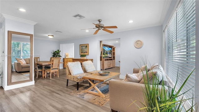 living room featuring ceiling fan, light hardwood / wood-style flooring, and crown molding