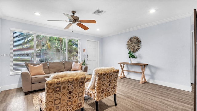 living room featuring ceiling fan, light hardwood / wood-style flooring, and crown molding