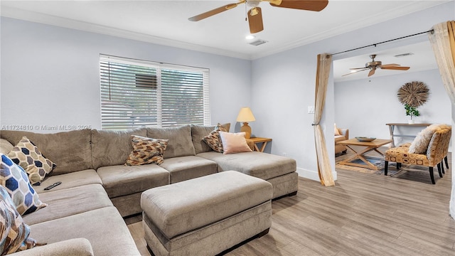 living room featuring ceiling fan, ornamental molding, and light hardwood / wood-style flooring