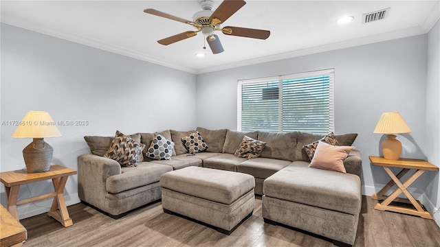 living room featuring hardwood / wood-style flooring, ceiling fan, and ornamental molding