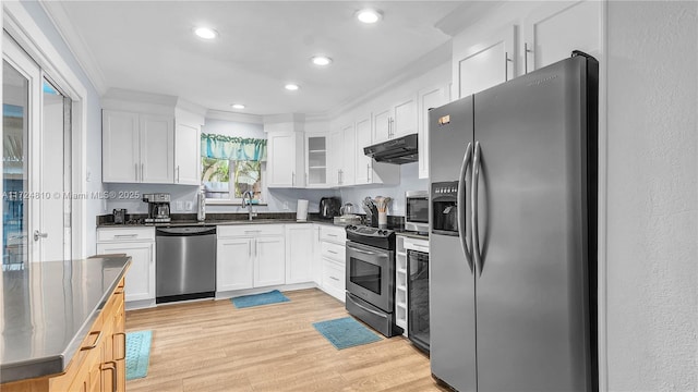 kitchen featuring white cabinetry, light wood-type flooring, ornamental molding, and appliances with stainless steel finishes