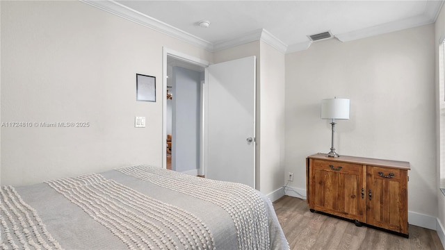 bedroom featuring light wood-type flooring and crown molding