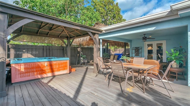 wooden terrace with a gazebo, french doors, ceiling fan, and a hot tub