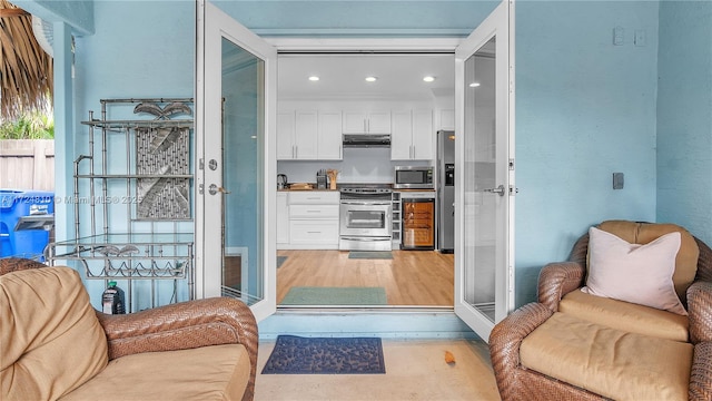 kitchen featuring appliances with stainless steel finishes, white cabinets, and wine cooler