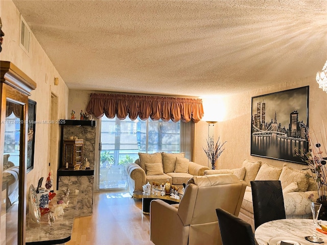 living room with wood-type flooring and a textured ceiling