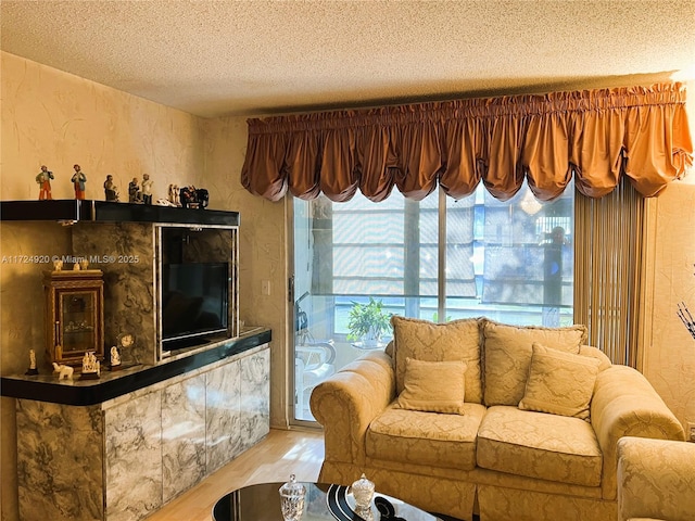 living room with light wood-type flooring and a textured ceiling