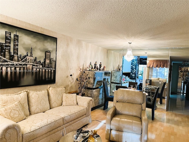 living room featuring hardwood / wood-style floors, a textured ceiling, and an inviting chandelier