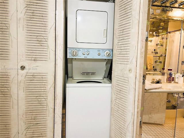 laundry area featuring sink, light tile patterned floors, and stacked washing maching and dryer