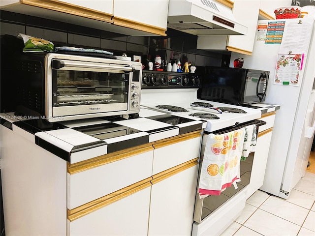 kitchen featuring white cabinets, white appliances, light tile patterned floors, and tile countertops