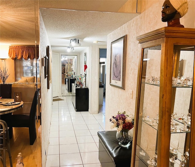 hallway with light tile patterned flooring and a textured ceiling