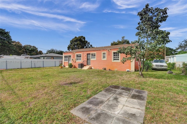 back of house featuring a lawn, central AC, and a patio