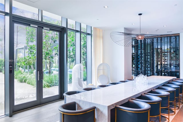 dining area with expansive windows and light wood-type flooring