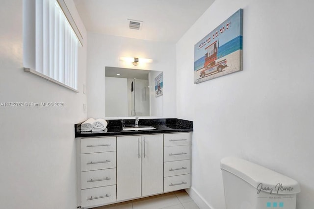 bathroom featuring tile patterned flooring, vanity, and toilet